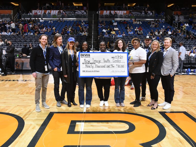 Recipients of Orlando Magic grant along with DeVos Family on basketball court